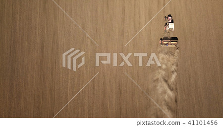 Aerial view of Tractor harvesting field tilling soil Aerial view of Tractor harvesting field tilling soil 41101456