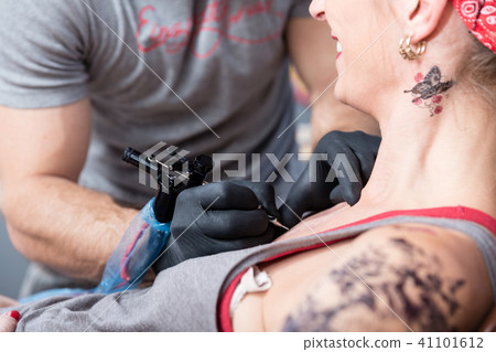Skilled artist making the contour of a new tattoo on the skin of a client Skilled artist making the contour of a new tattoo on the skin of a client 41101612