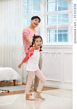 Dad and daughter playing happily in the living room Dad and daughter playing happily in the living room 41101636
