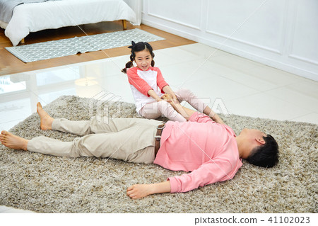 可愛的女兒把打盹的父親叫醒 41102023