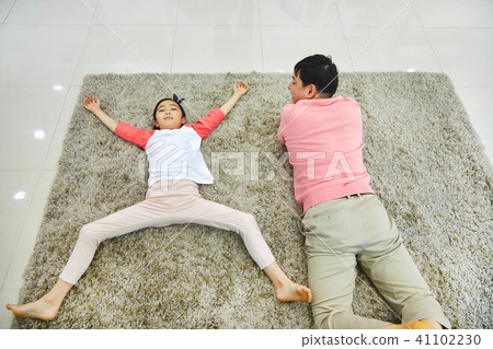 Dad and daughter having a good time lying in the living room 41102230