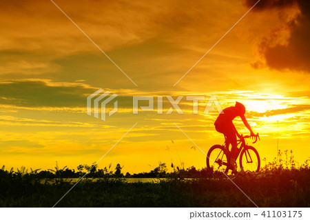 Backside of cyclist ride bicycle on sunset time Backside of cyclist ride bicycle on sunset time 41103175