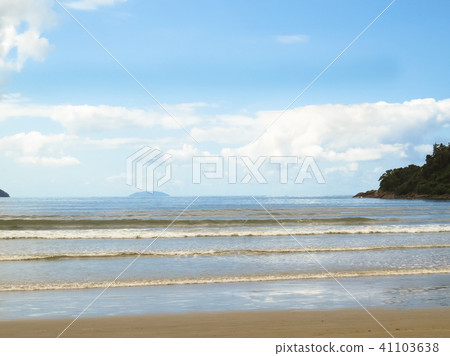 View of beach with waves and island. 41103638
