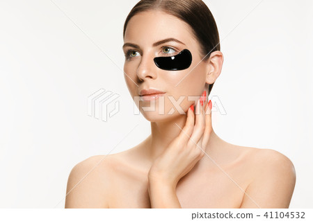 Young beautiful woman applying a mask for the face of the therapeutic black mud. Spa treatment Young beautiful woman applying a mask for the face of the therapeutic black mud. Spa treatment 41104532