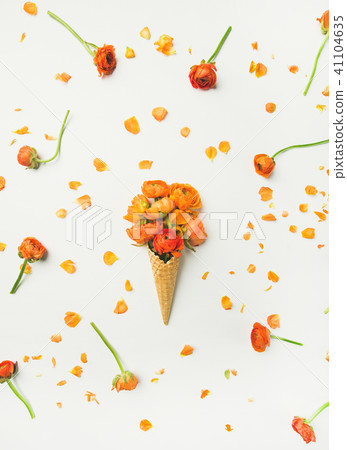 Waffle cone with orange buttercup flowers over white background 41104635