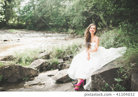Portrait of stunning bride with long hair standing by the river Portrait of stunning bride with long hair standing by the river 41104832