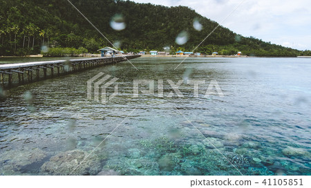Wooden jetty near Yenbuba village leading to Mansuar island in Raja Ampat. Beautiful corals in Wooden jetty near Yenbuba village leading to Mansuar island in Raja Ampat. Beautiful corals in 41105851