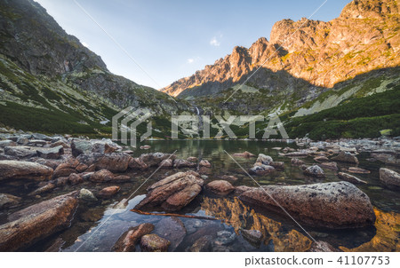 Mountain Lake with Rocks in Foreground at Sunset 41107753