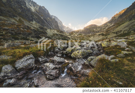 Creek in the Valley under the Mountain Peaks 41107817