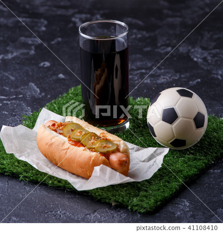 Photo of glass of beer, green grass with soccer ball, hotdog 41108410