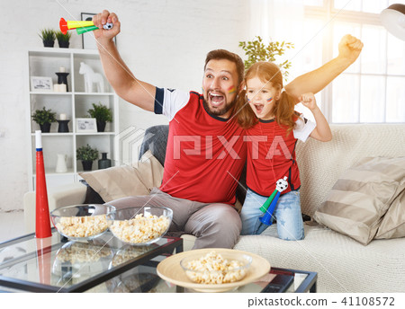 family of fans watching a football match on TV family of fans watching a football match on TV 41108572