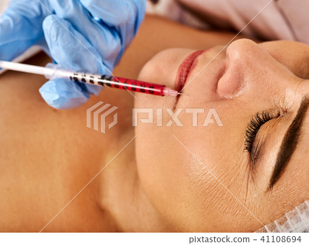 Dermal fillers lips of woman in spa salon with beautician. Dermal fillers lips of woman in spa salon with beautician. 41108694