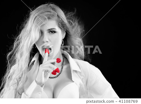 Woman eating berry. Pin up girl wearing unbuttoned blouse and bra. 41108769