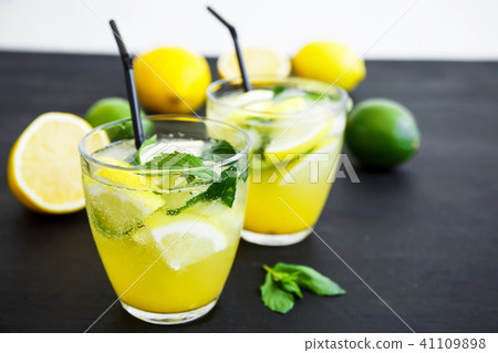 Refreshing lemonade in glass with limes, lemons 41109898