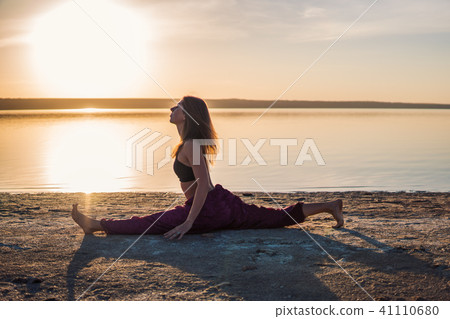 Silhouette yoga woman on the beach at sunset. Silhouette yoga woman on the beach at sunset. 41110680