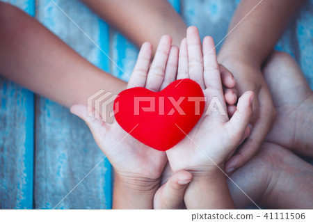 Red heart in child and parent hands with love Red heart in child and parent hands with love 41111506