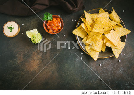 Nachos chips and various sauces Nachos chips and various sauces 41111636