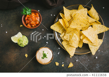 Nachos chips and various sauces Nachos chips and various sauces 41111638