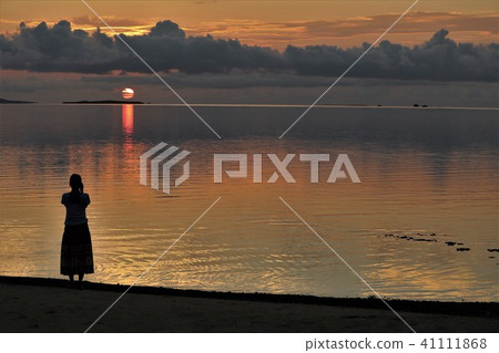 A woman nestling in the sunset 41111868