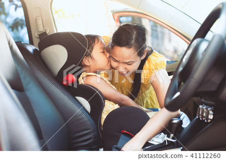 mother is fastening security belt to her daughter mother is fastening security belt to her daughter 41112260