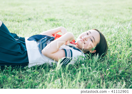 High school student who lies on the lawn and reads books High school student who lies on the lawn and reads books 41112901