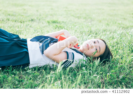 High school student who lies on the lawn and reads books High school student who lies on the lawn and reads books 41112902