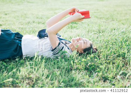 High school student who lies on the lawn and reads books 41112912