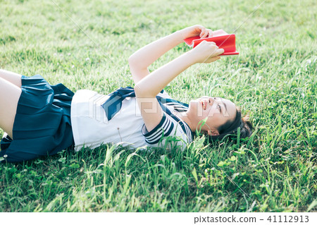 High school student who lies on the lawn and reads books High school student who lies on the lawn and reads books 41112913