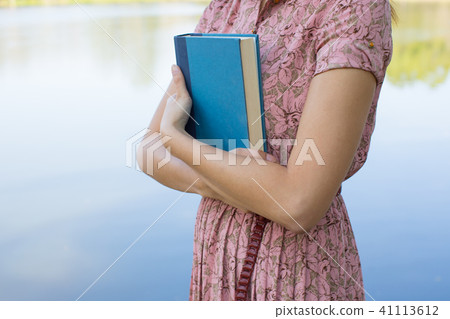 Young woman reading bible in natural park 41113612