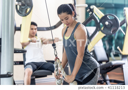 Determined young woman exercising cable rope triceps extension Determined young woman exercising cable rope triceps extension 41118213