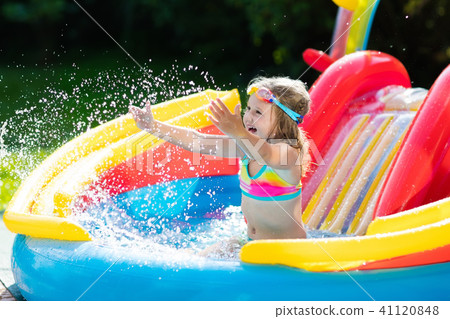 Child in garden swimming pool with slide 41120848