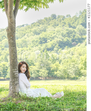 Young female model sitting on the lawn Young female model sitting on the lawn 41121177