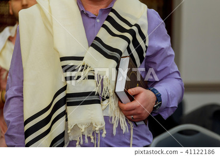 Hands holding a jewish prayer book a prayer shawl Hands holding a jewish prayer book a prayer shawl 41122186