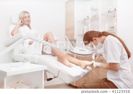 Podiatrist making procedure for client foot with special equipme Podiatrist making procedure for client foot with special equipme 41123558
