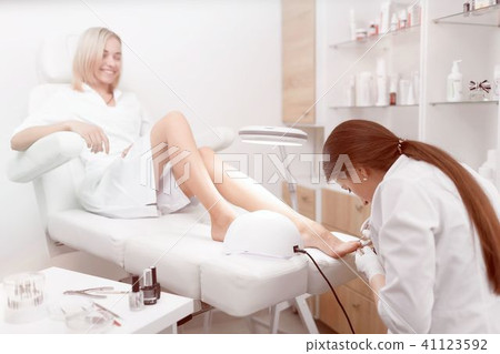 Specialist in white cleaning cuticle around nails on feet and po Specialist in white cleaning cuticle around nails on feet and po 41123592