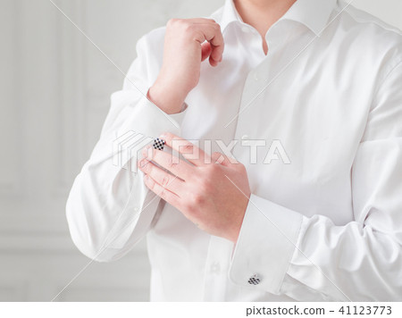 Man in white shirt adjusts his cufflinks. Man in white shirt adjusts his cufflinks. 41123773