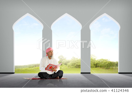 Senior asian muslim man sitting with Koran Senior asian muslim man sitting with Koran 41124346