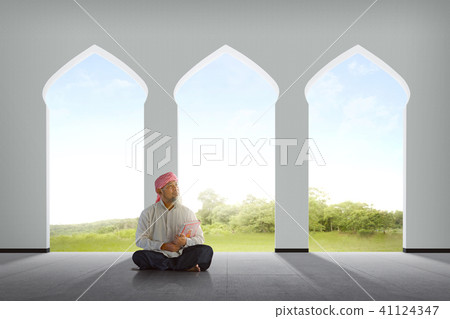 Elderly asian muslim man holding Koran Elderly asian muslim man holding Koran 41124347