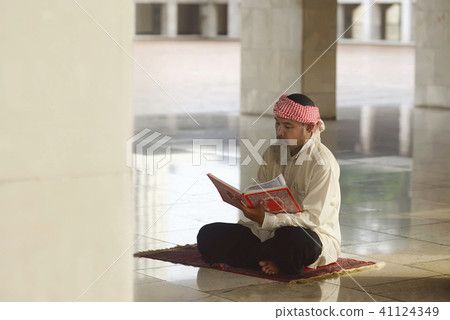 Elderly asian muslim man reading the Koran Elderly asian muslim man reading the Koran 41124349