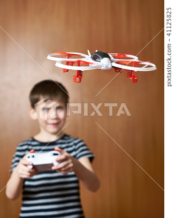Happy little boy drives toy quadcopter drone 41125825
