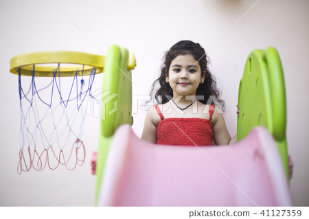 Girl with slide and basketball hoop Girl with slide and basketball hoop 41127359