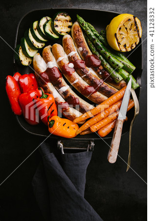 Sausages with sauce and vegetables on frying pan Sausages with sauce and vegetables on frying pan 41128332
