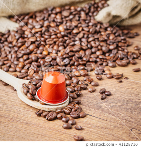 coffee capsule on wooden spoon and coffee beans 41128710