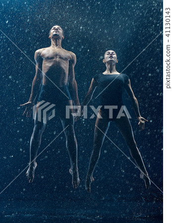 Young couple of ballet dancers dancing unde rwater drops Young couple of ballet dancers dancing unde rwater drops 41130143