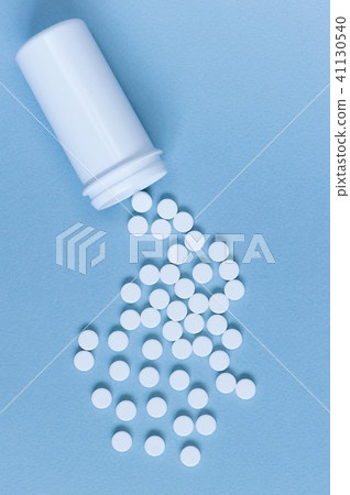 White pills scattered from the container White pills scattered from the container 41130540