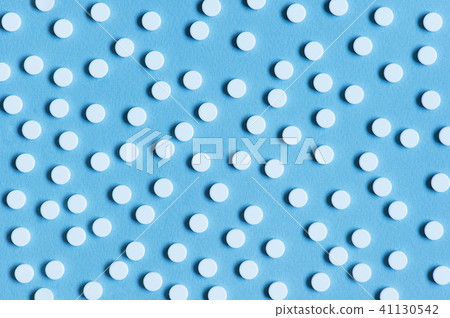 Blue textured background with white pills 41130542