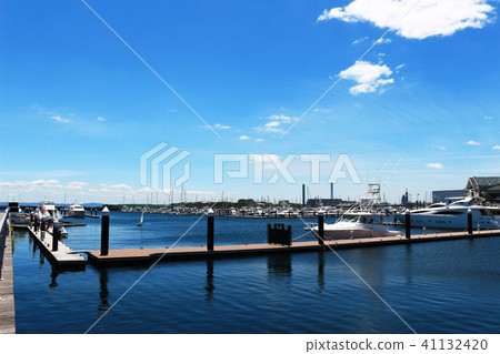 Luxurious summer view of the marina with a stylish cruiser moored Luxurious summer view of the marina with a stylish cruiser moored 41132420