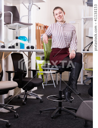 Salesgirl sitting on chair in furniture shop 41138153