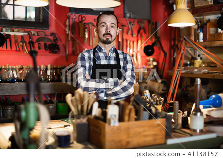 Male worker demonstrating workplace and tools in leather 41138157