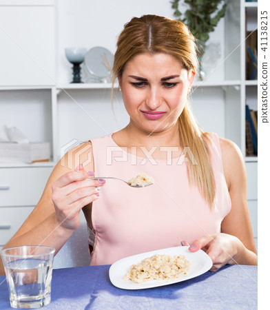 Sporty girl is feeling disgust when breakfast with oatmeal porridge 41138215
